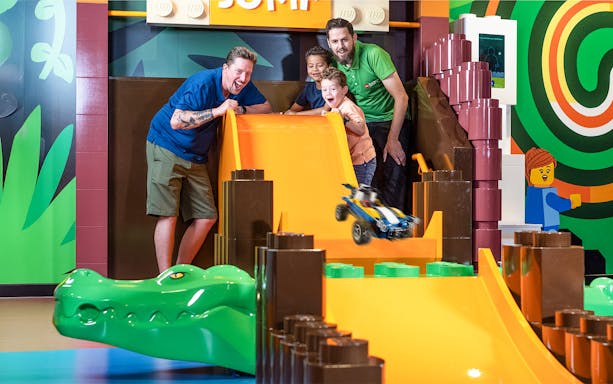Children playing with a LEGO car on a slide at LEGO Discovery Centre Hamburg.