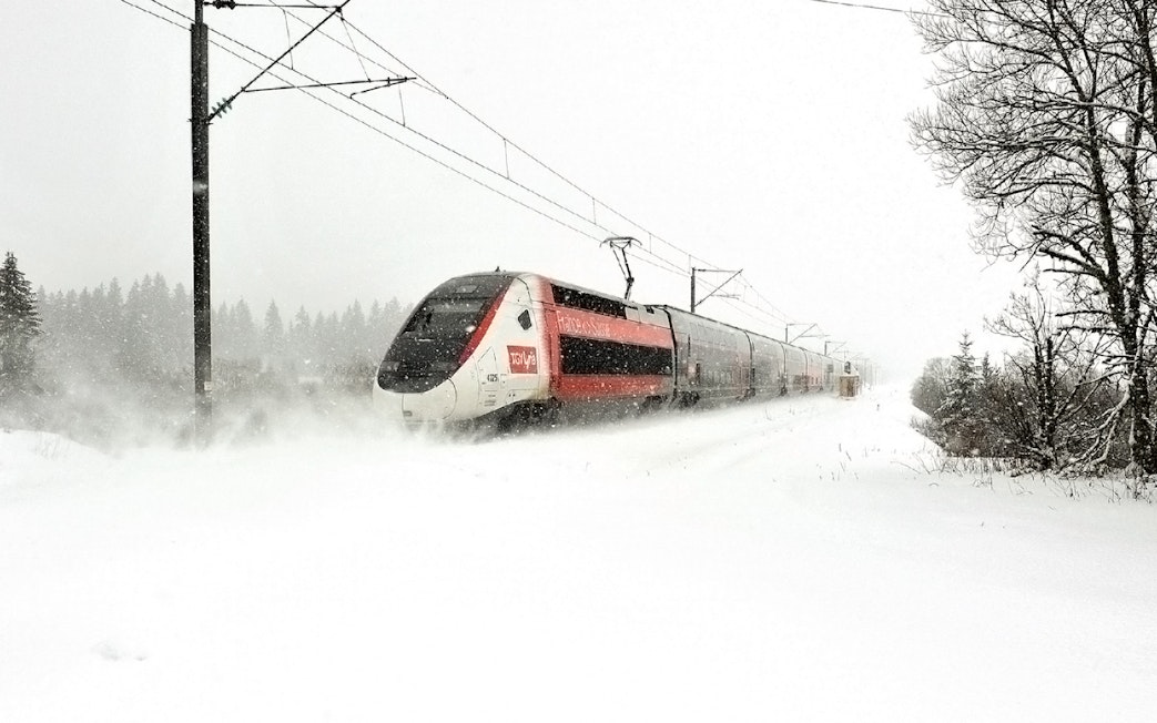 High-speed train traveling through snowy landscape, Eurail Global Continuous Pass.