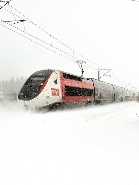 High-speed train traveling through snowy landscape, Eurail Global Continuous Pass.