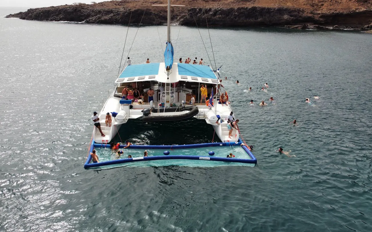Catamaran with adults swimming near Sal Island coast on an exclusive cruise.