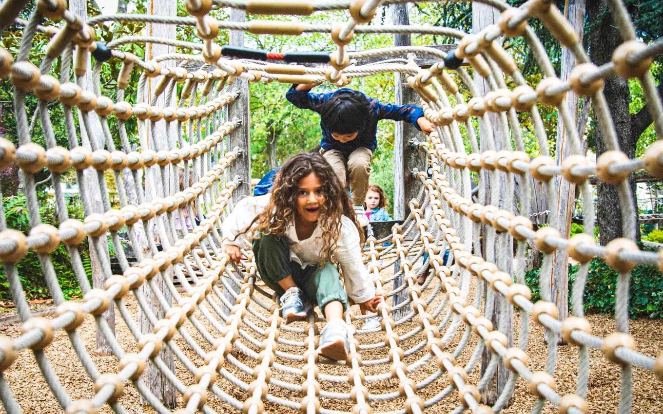 Children playing on a rope bridge at Jardin d'Acclimatation, Paris.