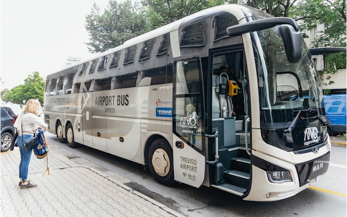 Airport bus for transfer from Venice Marco Polo, parked with a passenger nearby.