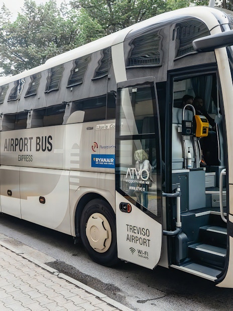 Airport bus for transfer from Venice Marco Polo, parked with a passenger nearby.