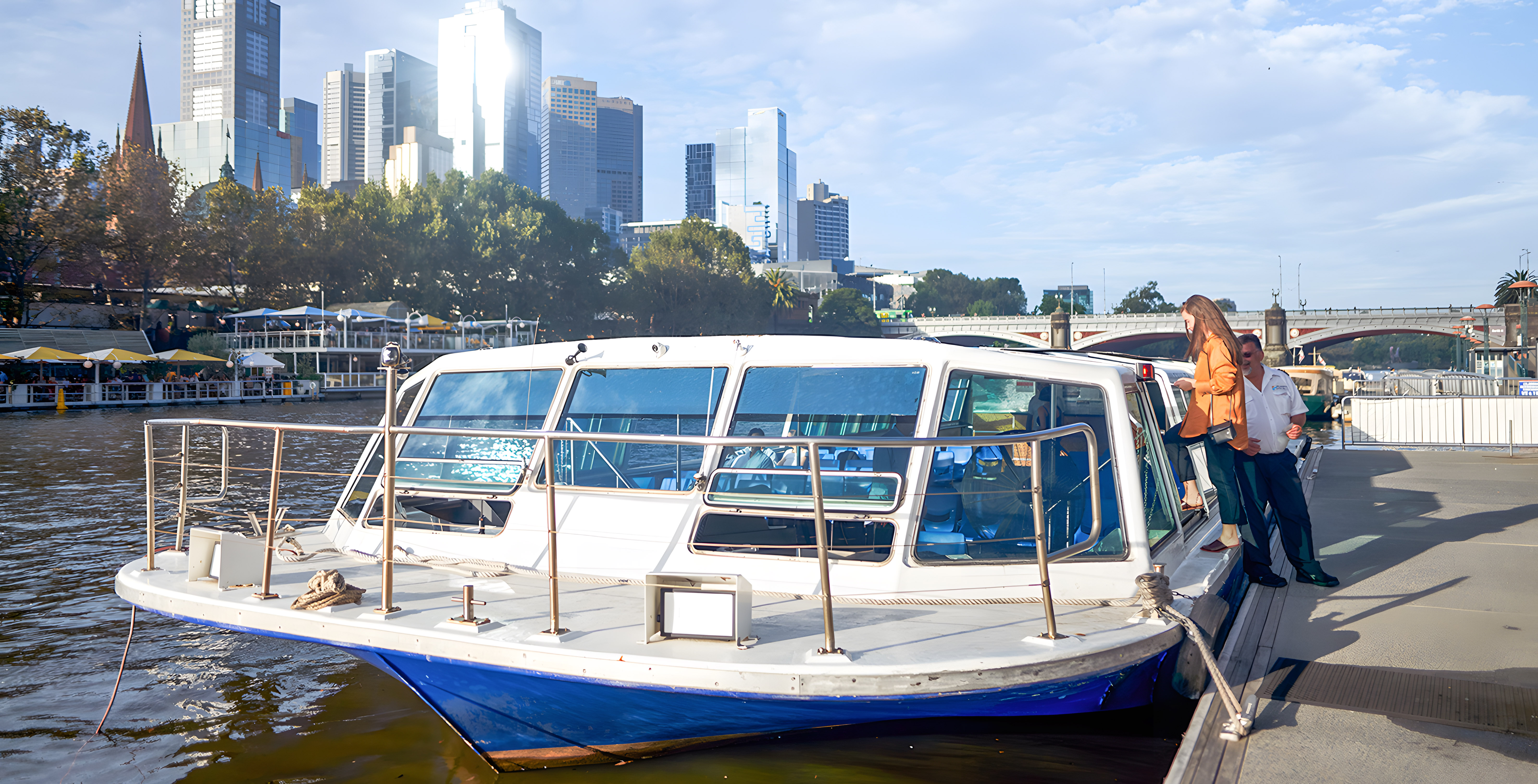Yarra River sightseeing cruise with Melbourne skyline in the background.