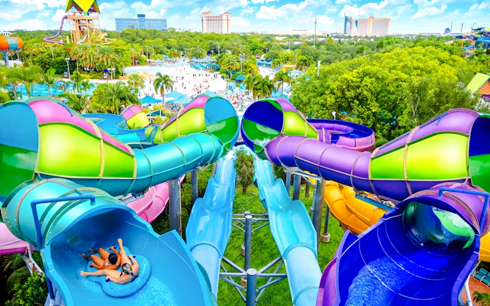 Water slides at Omaka Rocka, Aquatica Orlando, with people enjoying the ride.