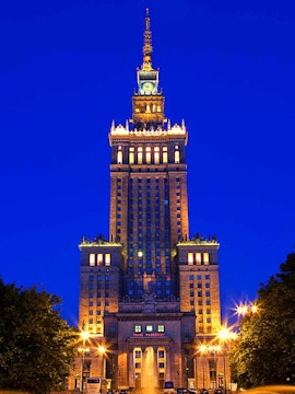 Palace of Culture and Science illuminated at night in Warsaw, Poland.