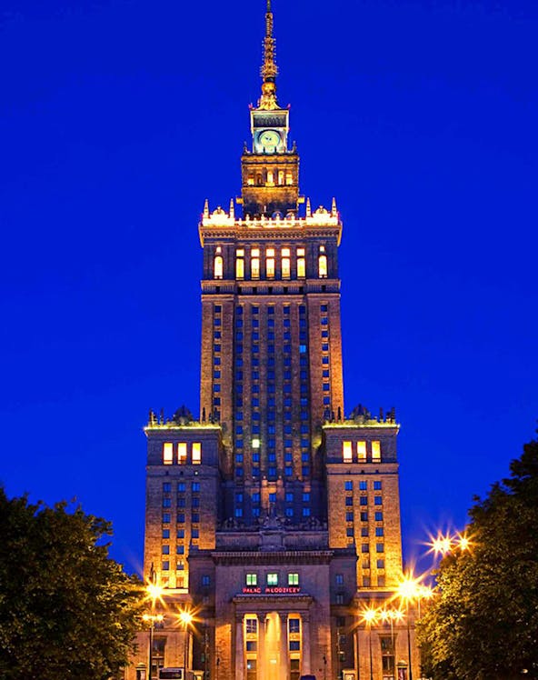 Palace of Culture and Science illuminated at night in Warsaw, Poland.
