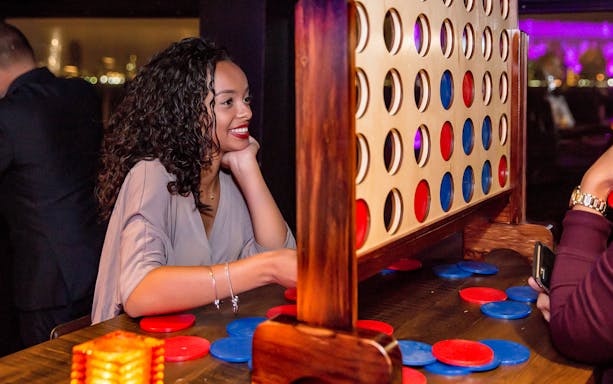 Person playing Connect Four on a New York party cruise.
