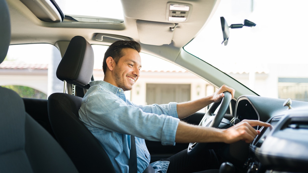 Man driving a car during a scenic road trip tour