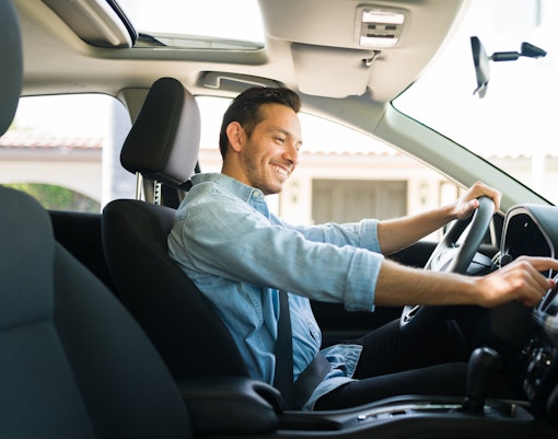 Man driving a car during a scenic road trip tour