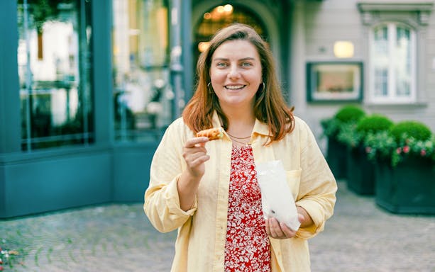 Woman enjoying Sicilian cannoli pastry in Boston.