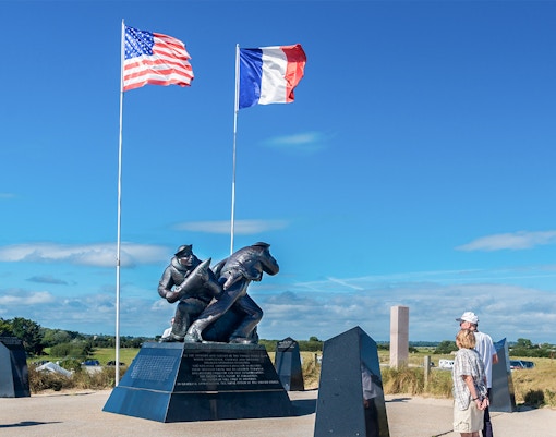 Normandy D-Day Tour guide explaining historical significance at Omaha Beach, France.