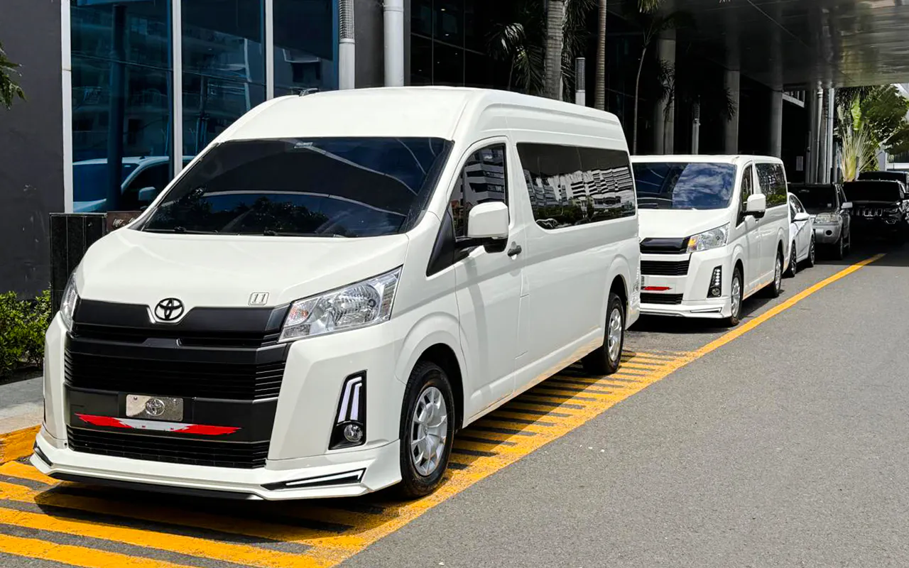 Shuttle vans for airport transfers in Panama City, parked outside a hotel.