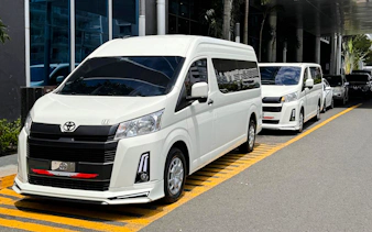 Shuttle vans for airport transfers in Panama City, parked outside a hotel.