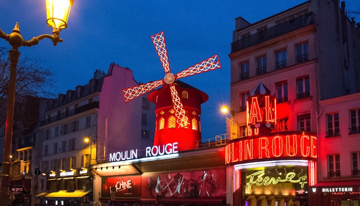 Moulin Rouge cabaret show in Paris with iconic red windmill.