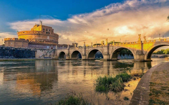 Castel Sant'Angelo and Ponte Sant'Angelo over the Tiber River at sunset in Rome.