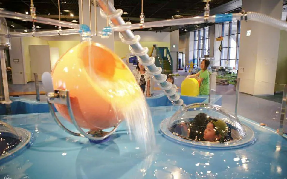 Children exploring interactive water exhibit at Kids Plaza Osaka.