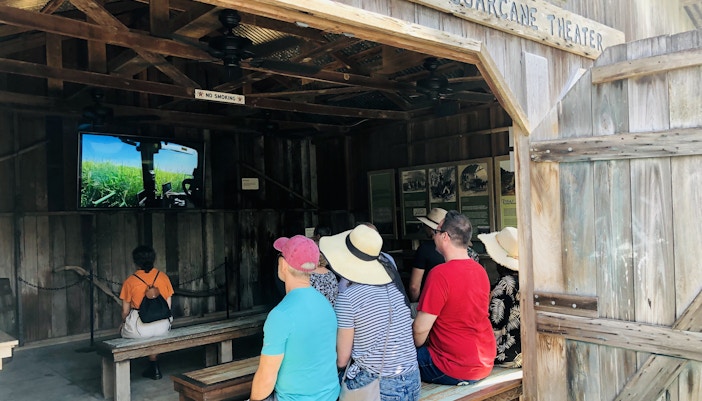 Visitors watching a video at Sugarcane Theater during Swamp Tour & Oak Alley Plantation Tour.