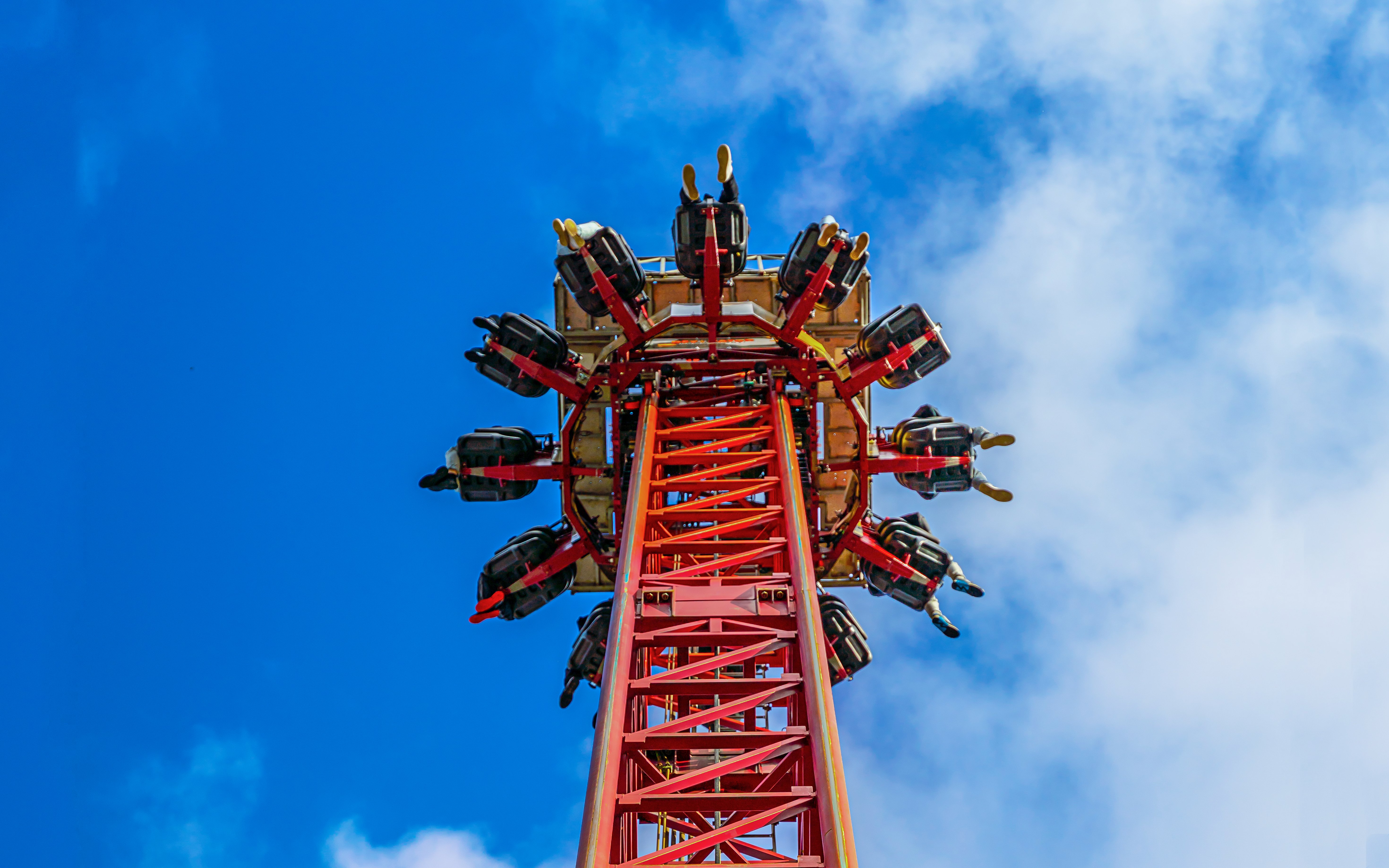 Thrill ride ascending at Thorpe Park against a blue sky.