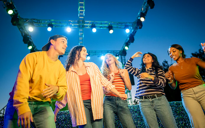 Guests enjoying Halloween Haunt zones at Dorney Park under colorful lights.