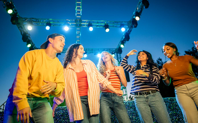 Guests enjoying Halloween Haunt zones at Dorney Park under colorful lights.