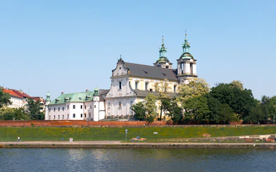 Vistula River cruise view of historic church and greenery in Krakow, Poland.