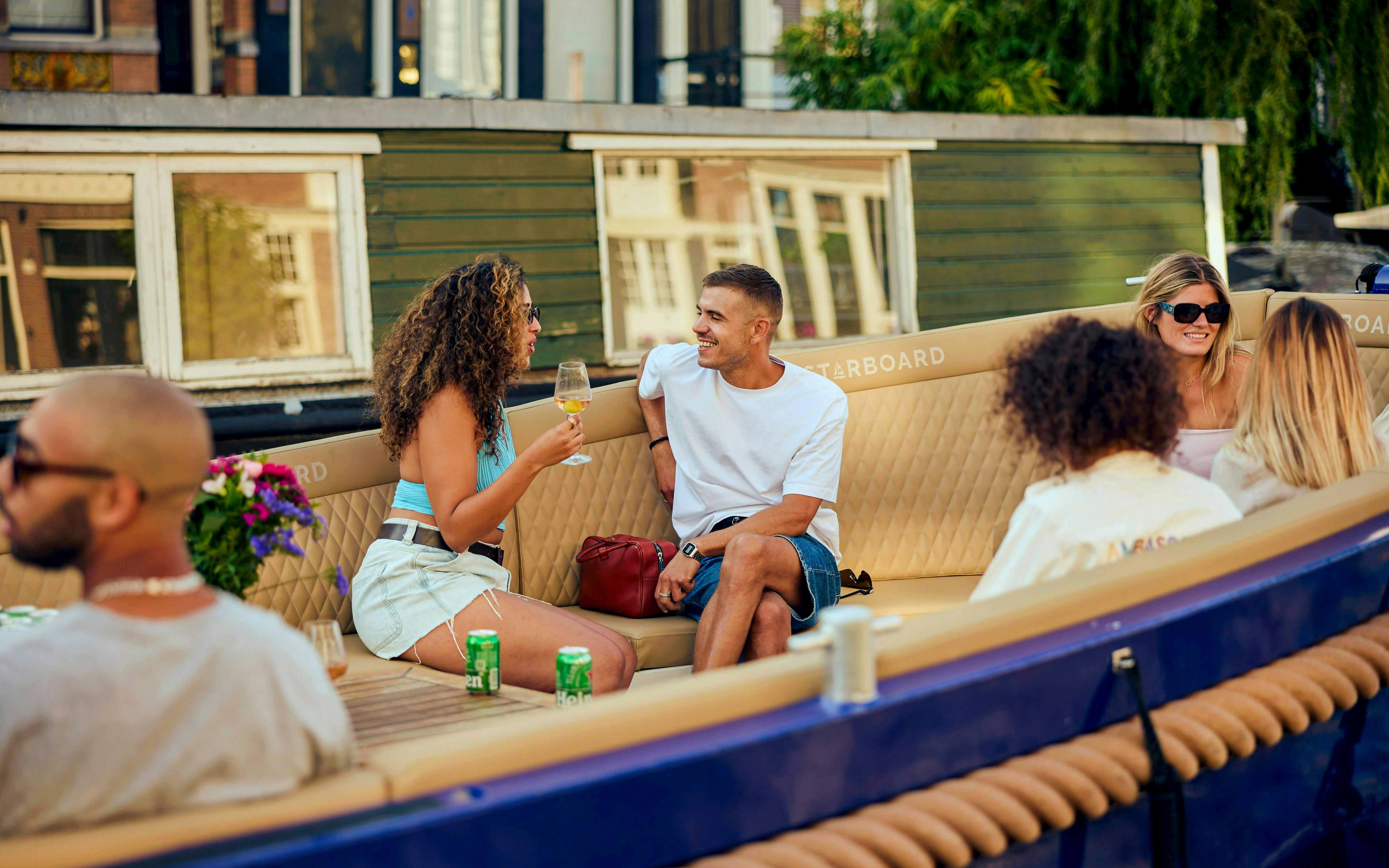 Guests enjoying drinks on a canal cruise in Amsterdam.