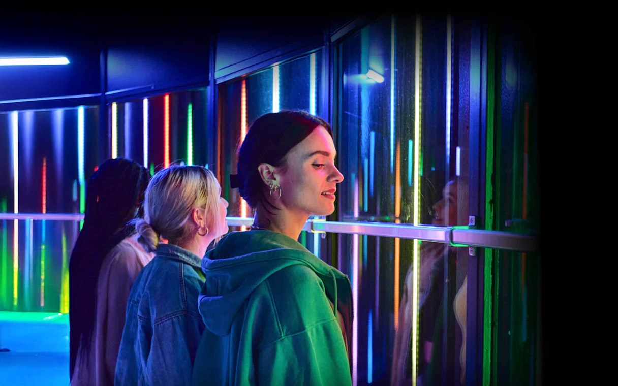 Visitors enjoying colorful lights at Euromast Lookout, Rotterdam.