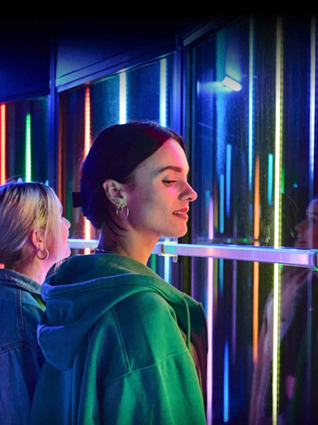 Visitors enjoying colorful lights at Euromast Lookout, Rotterdam.