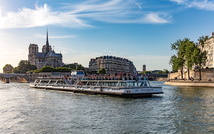 Bateaux Mouches cruising by Notre Dame Cathedral on the Seine River in Paris.
