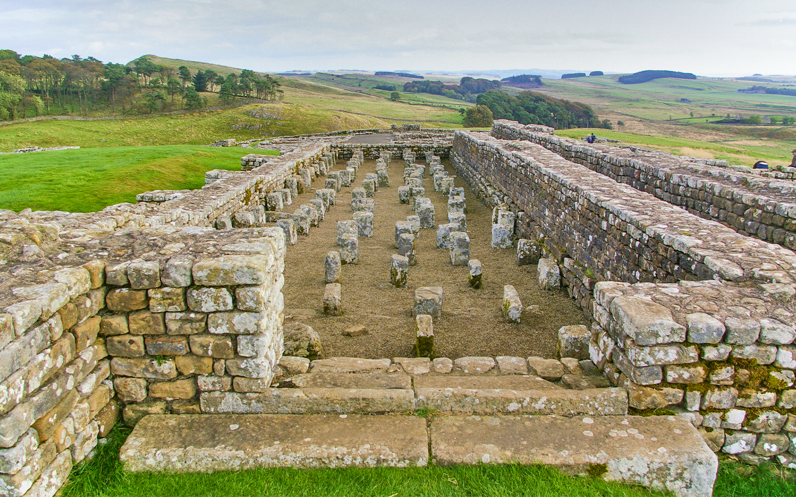 Housesteads Roman Fort ruins on Hadrian's Wall, Northumberland, England, showcasing ancient stone structures.