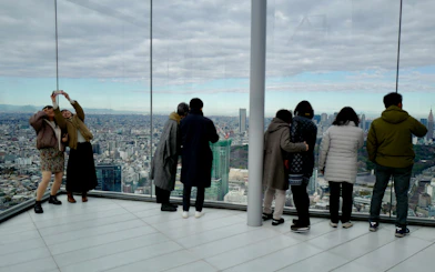 Visitors enjoying the view from SHIBUYA SKY observation deck in Tokyo.