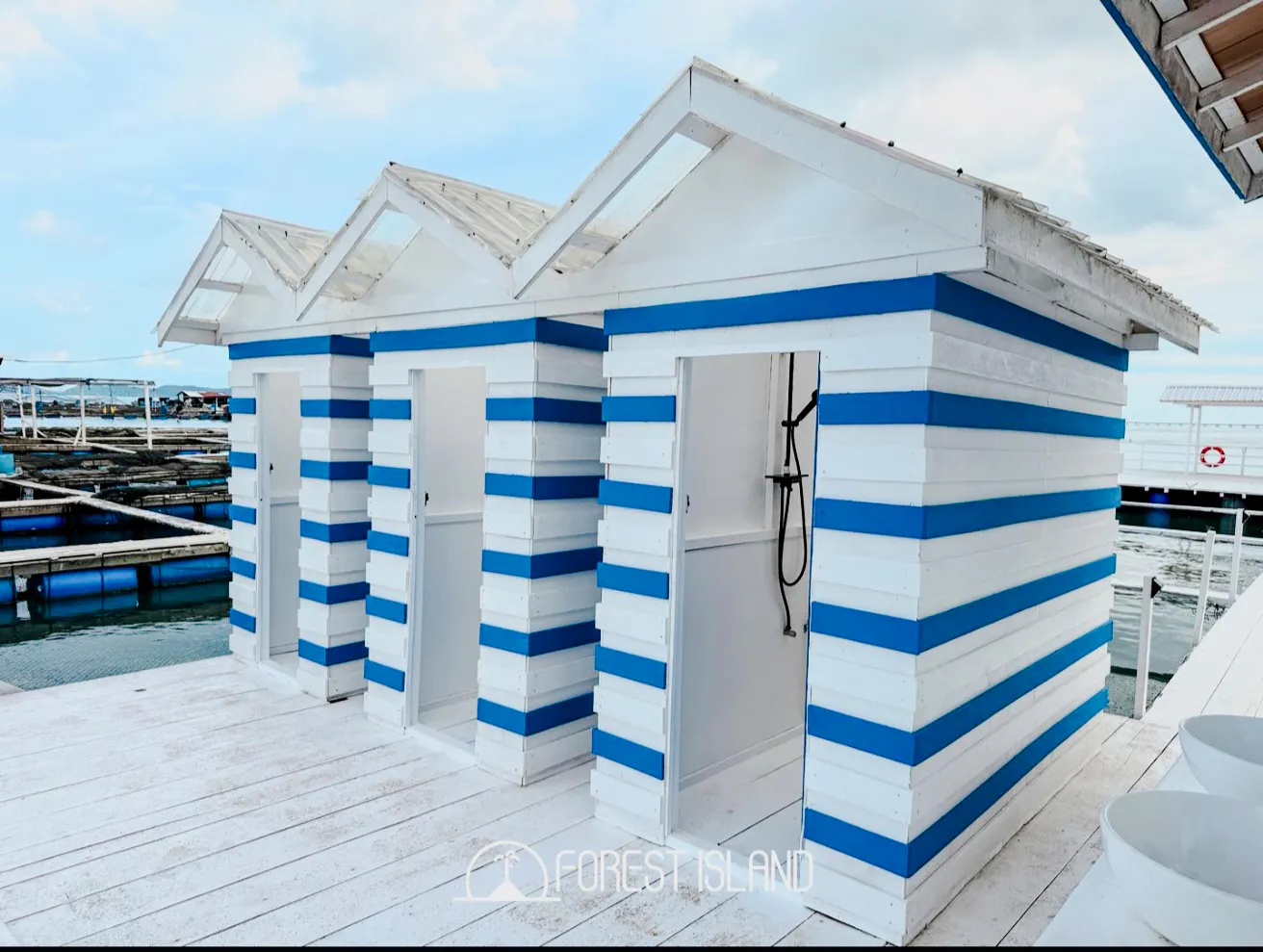 Striped beach huts on a dock at Forest Island, Penang, part of the catamaran cruise experience.
