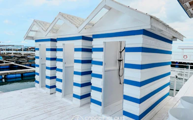 Striped beach huts on a dock at Forest Island, Penang, part of the catamaran cruise experience.
