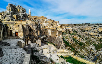 Matera's ancient stone buildings and winding paths on a guided tour.
