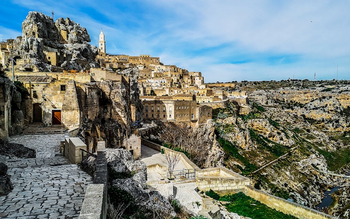 Matera's ancient stone buildings and winding paths on a guided tour.