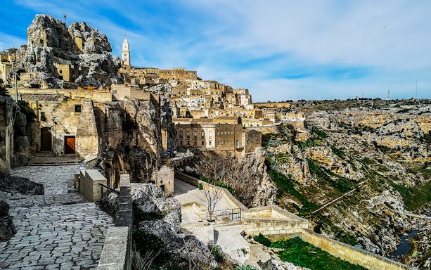 Matera's ancient stone buildings and winding paths on a guided tour.