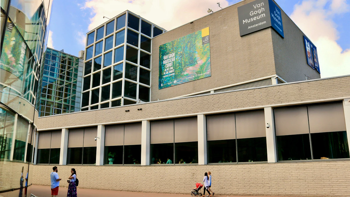 Van Gogh Museum exterior in Amsterdam with visitors walking nearby.