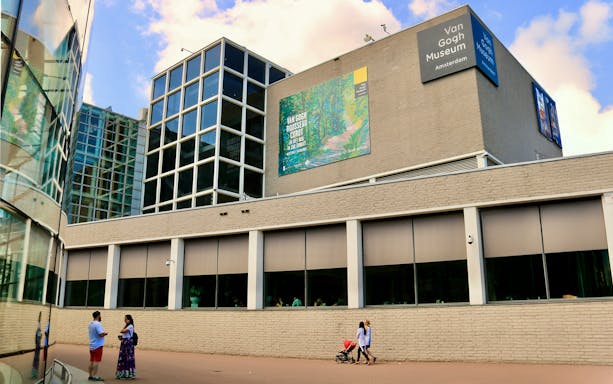 Van Gogh Museum exterior in Amsterdam with visitors walking nearby.
