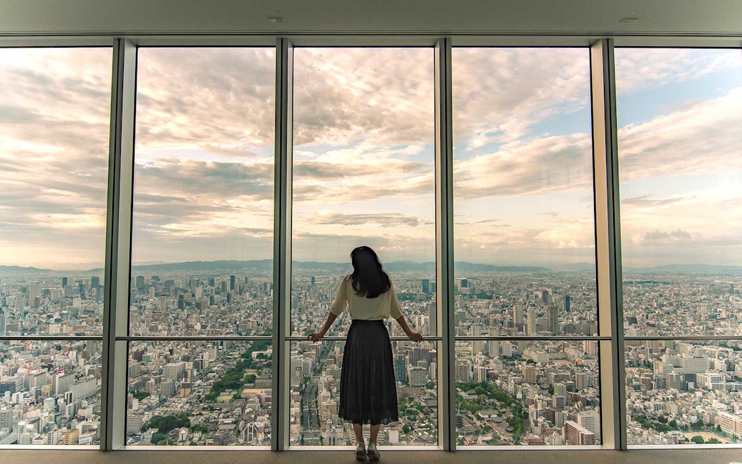 Woman viewing Osaka skyline from Harukas 300 Observatory.