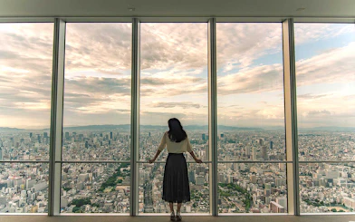 Woman viewing Osaka skyline from Harukas 300 Observatory.