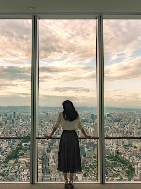 Woman viewing Osaka skyline from Harukas 300 Observatory.
