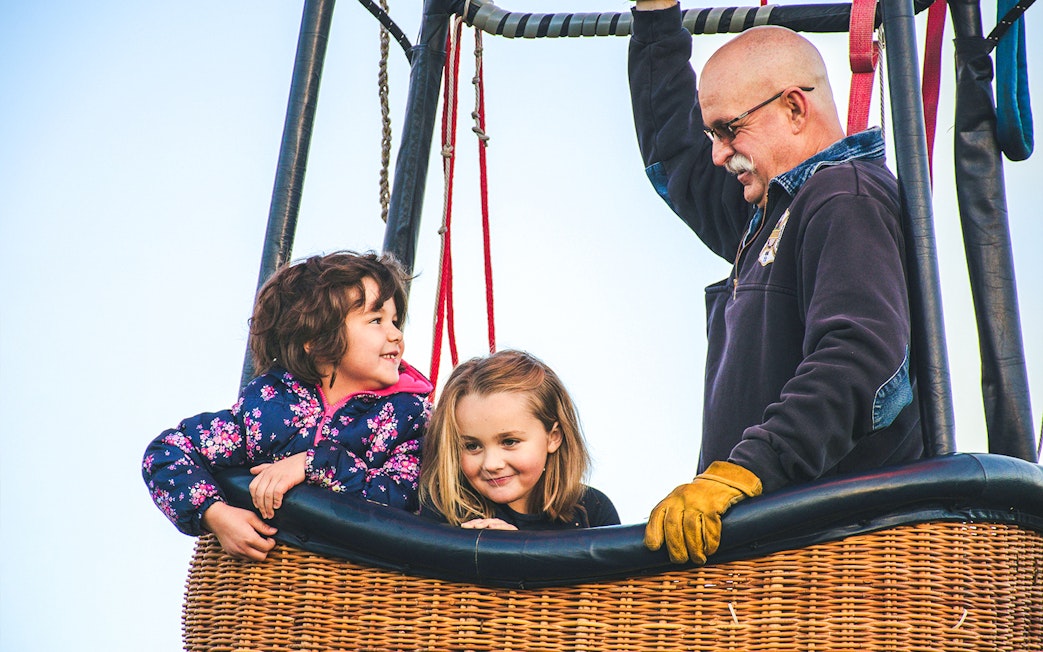 Children and pilot in a hot air balloon basket in Luxor.