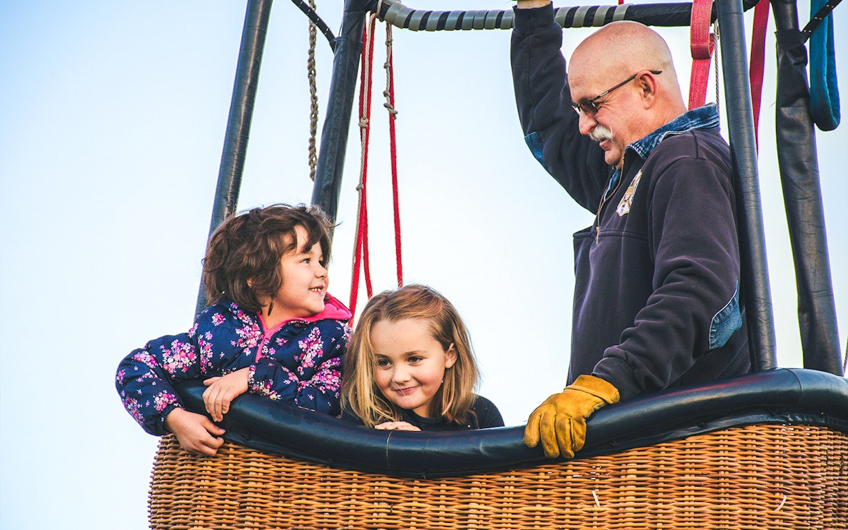 Children and pilot in a hot air balloon basket in Luxor.