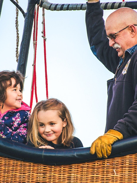 Children and pilot in a hot air balloon basket in Luxor.