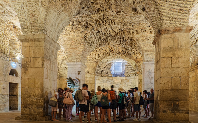 Tour group exploring Diocletian's Cellar in Split, Croatia.