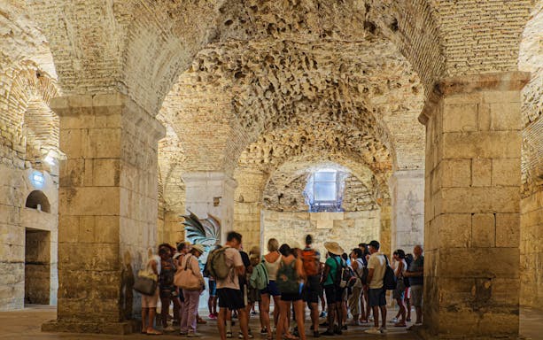 Tour group exploring Diocletian's Cellar in Split, Croatia.