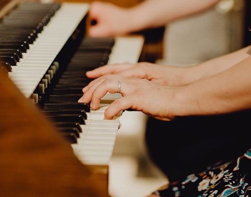 Baroque church interior with grand piano set for concert in ornate setting.