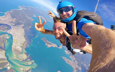 Tandem skydiving over Newcastle, Australia with ocean and city views.