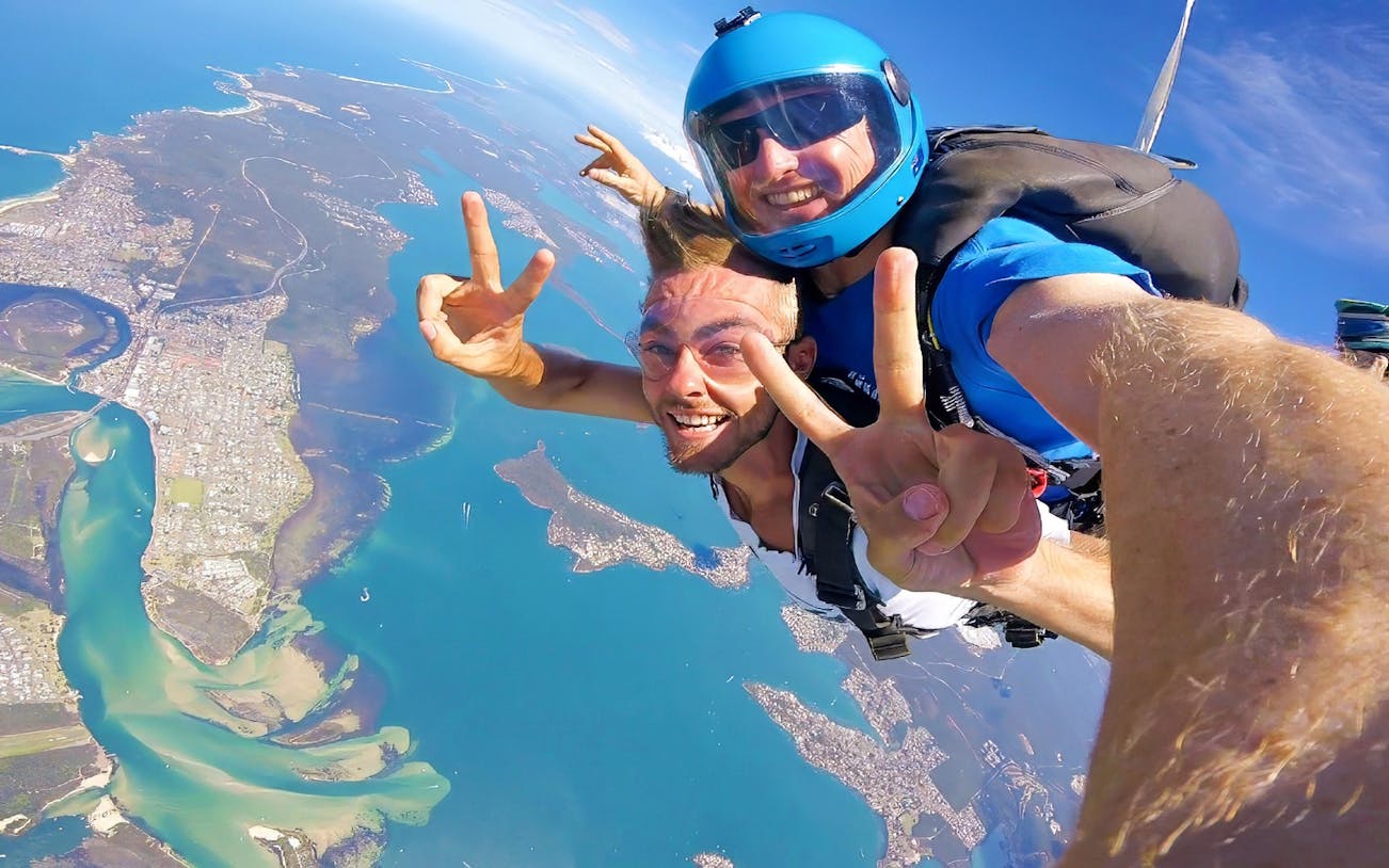 Tandem skydiving over Newcastle, Australia with ocean and city views.